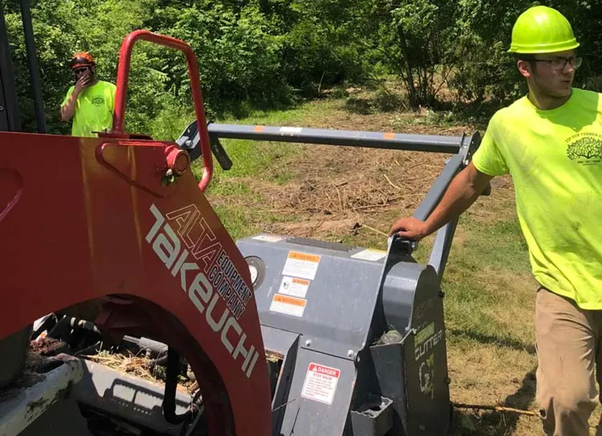 Crew member running a forestry mulcher for brush hogging